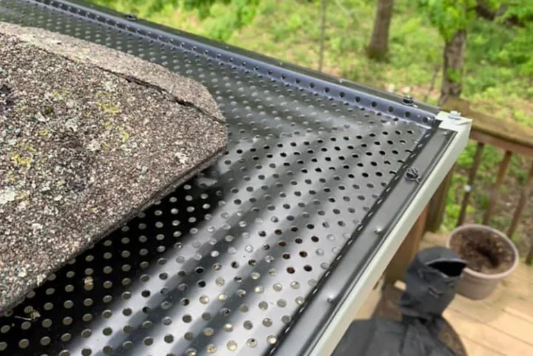 Professionally installed black perforated gutter guards protecting residential gutters from debris